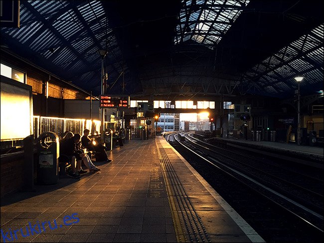 Interior de la estación de tren con puesta de sol en segundo plano.