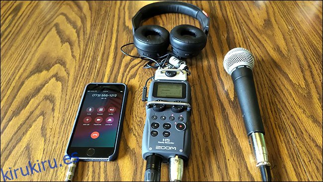 Un iPhone, un micrófono Shure SM58 y auriculares, todos conectados a una grabadora H5 Zoom, sobre una mesa.