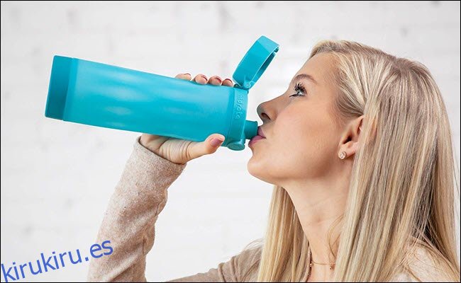 Una mujer bebiendo de una botella de agua inteligente.