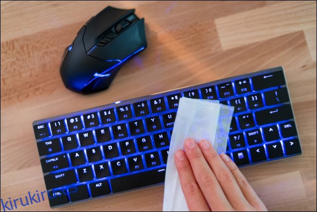 Una mano limpiando un teclado separado.