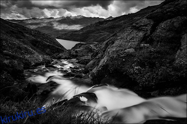 Una foto en blanco y negro de un arroyo en las montañas después de que llovió.