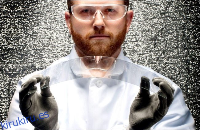 Un científico sosteniendo un trozo de vidrio Corning flexible.