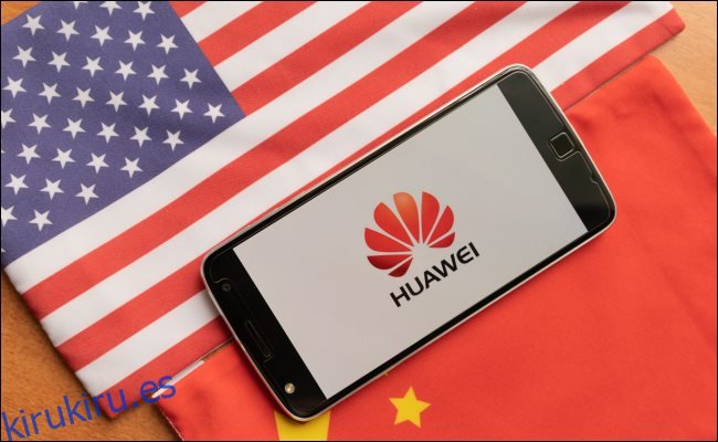 Un teléfono Huawei entre una bandera de Estados Unidos y China.