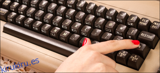 Una mujer escribiendo en un teclado antiguo.