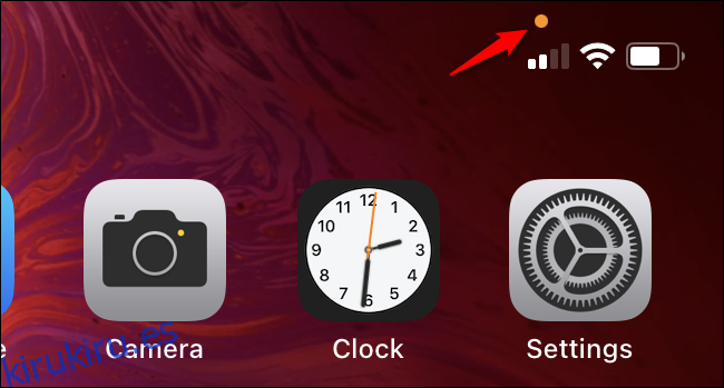 El círculo naranja sobre el indicador de celular en un iPhone.